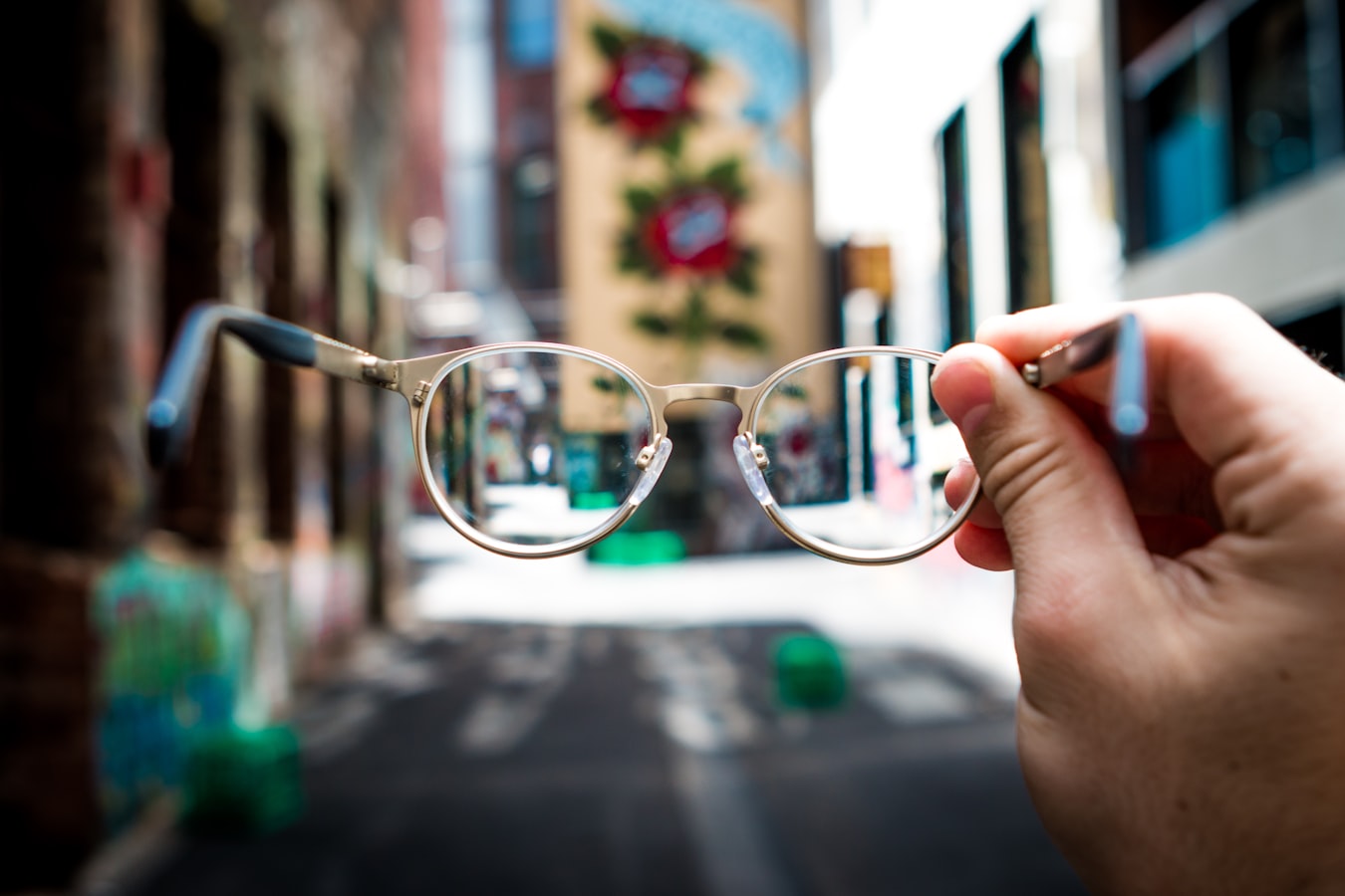 A pair of glasses looking at an out of focus neighborhood