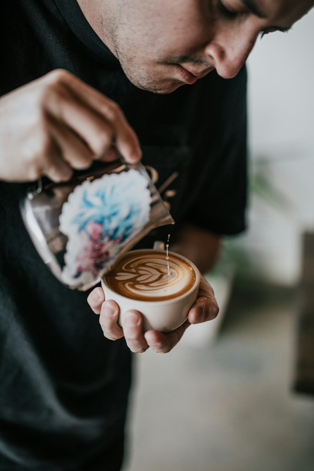 person holding mug and making cappuccino