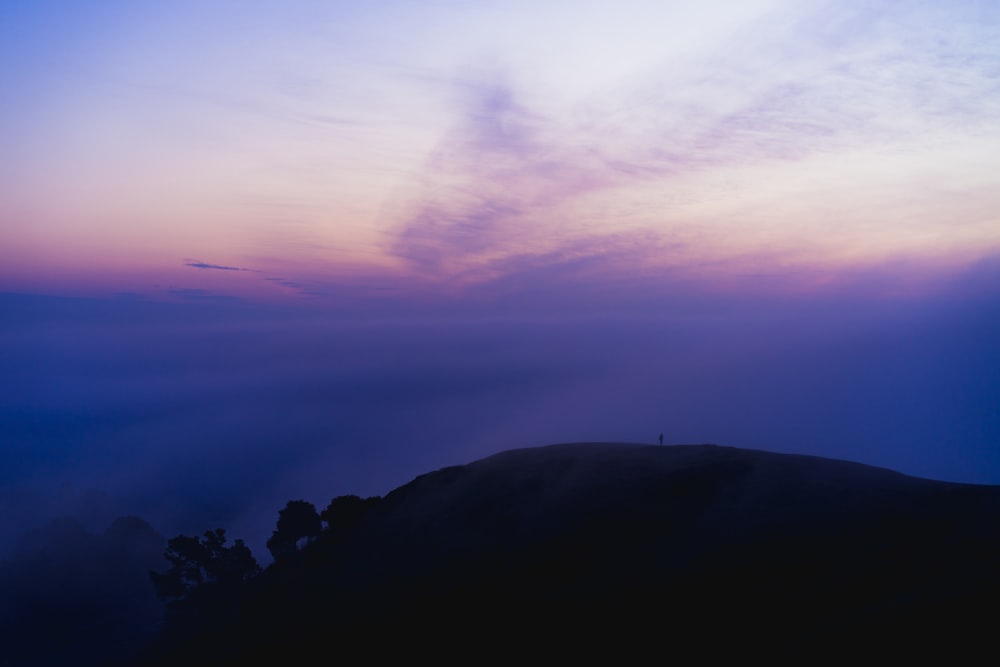 silhueta da montanha sob o céu roxo