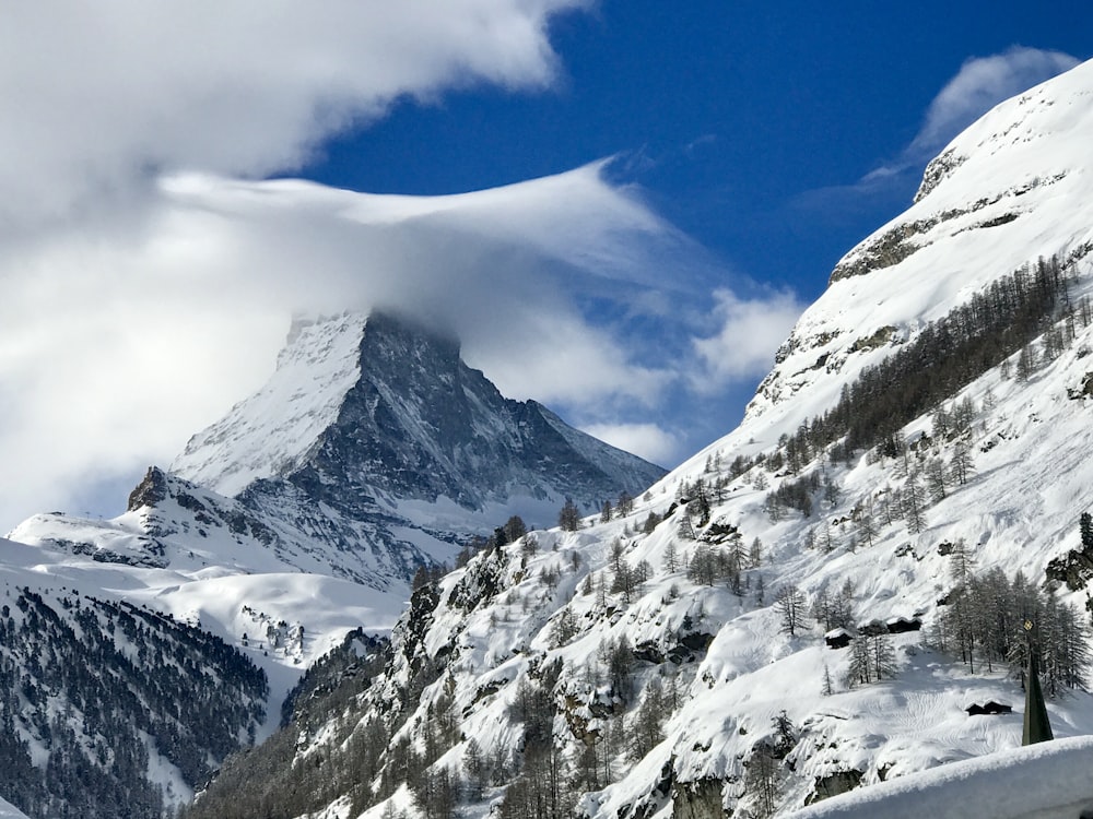 snow covered mountains under cloudy sky