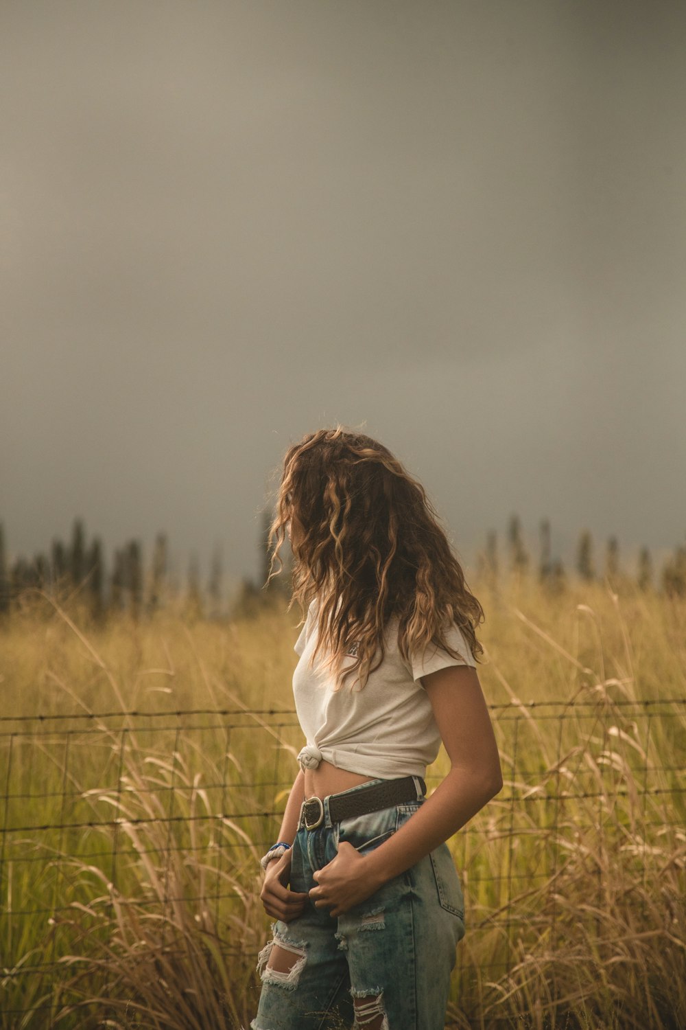 woman standing beside fence and plants during daytime