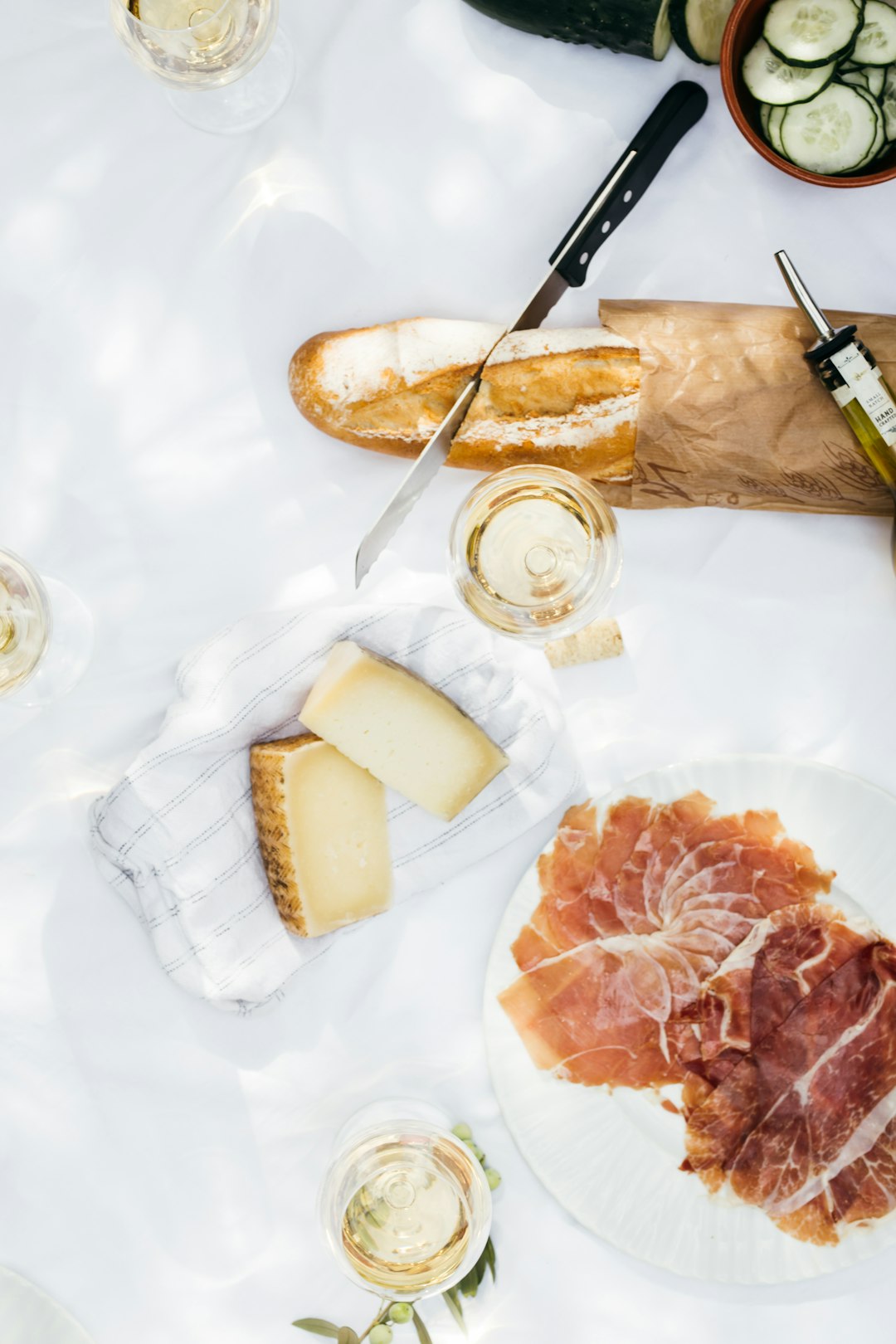 flat lay photography of cheese near jar filled with clear liquid next to bread