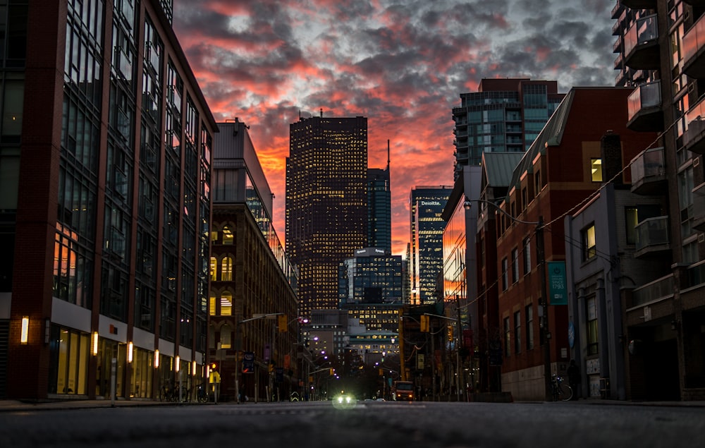 city buildings under gray clouds during sunset