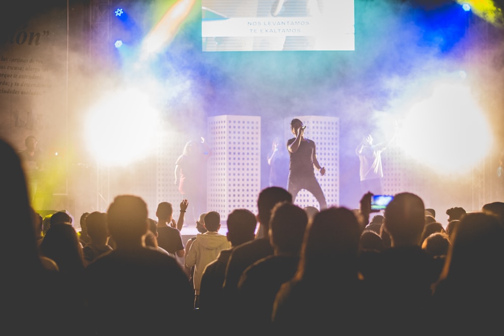 man singing in concert surrounded by people