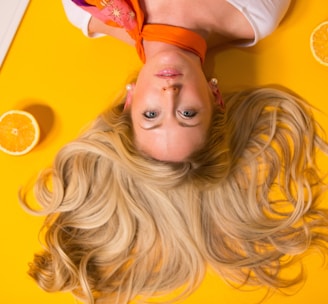 photo of woman leaning on yellow surface