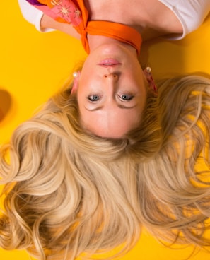 photo of woman leaning on yellow surface