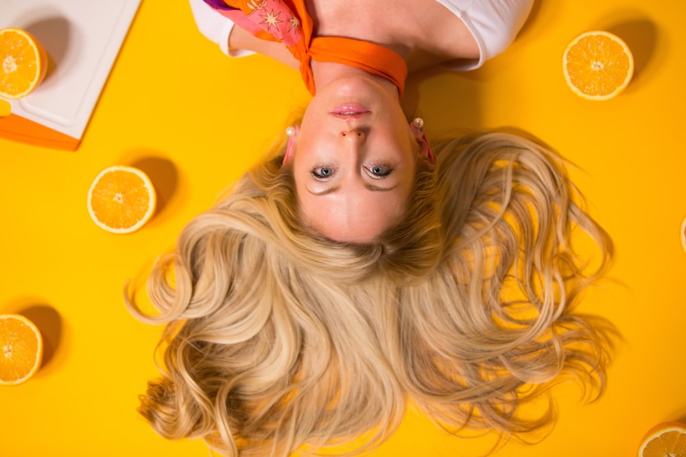 Photo d’une femme appuyée sur une surface jaune