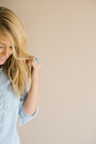 A candid moment of a client running fingers through her long, natural-looking extensions in natural light.