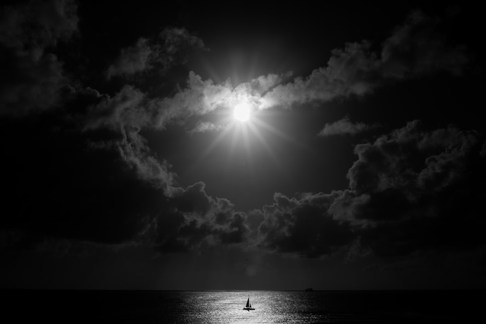 grayscale photo of body of water under sky