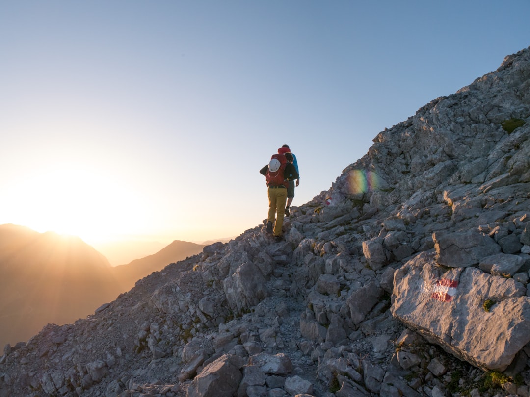 person climbing on mountain, Peaking at 2713m, the Watzmann is the second hightest mountain in Germany. The crossing across the three peaks is a famous and popular, yet challanging and time consuming route. Most people stay overnight at the Watzmannhaus in order to start the hike early the next morning.<p></figure>The moment when first light touches the mountain is truly magnificent, knowing the day only starts and a long hike stands before.
