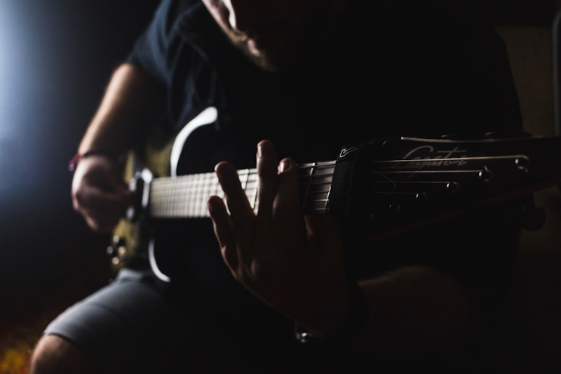 Guitarist playing in low light on a dark stage
