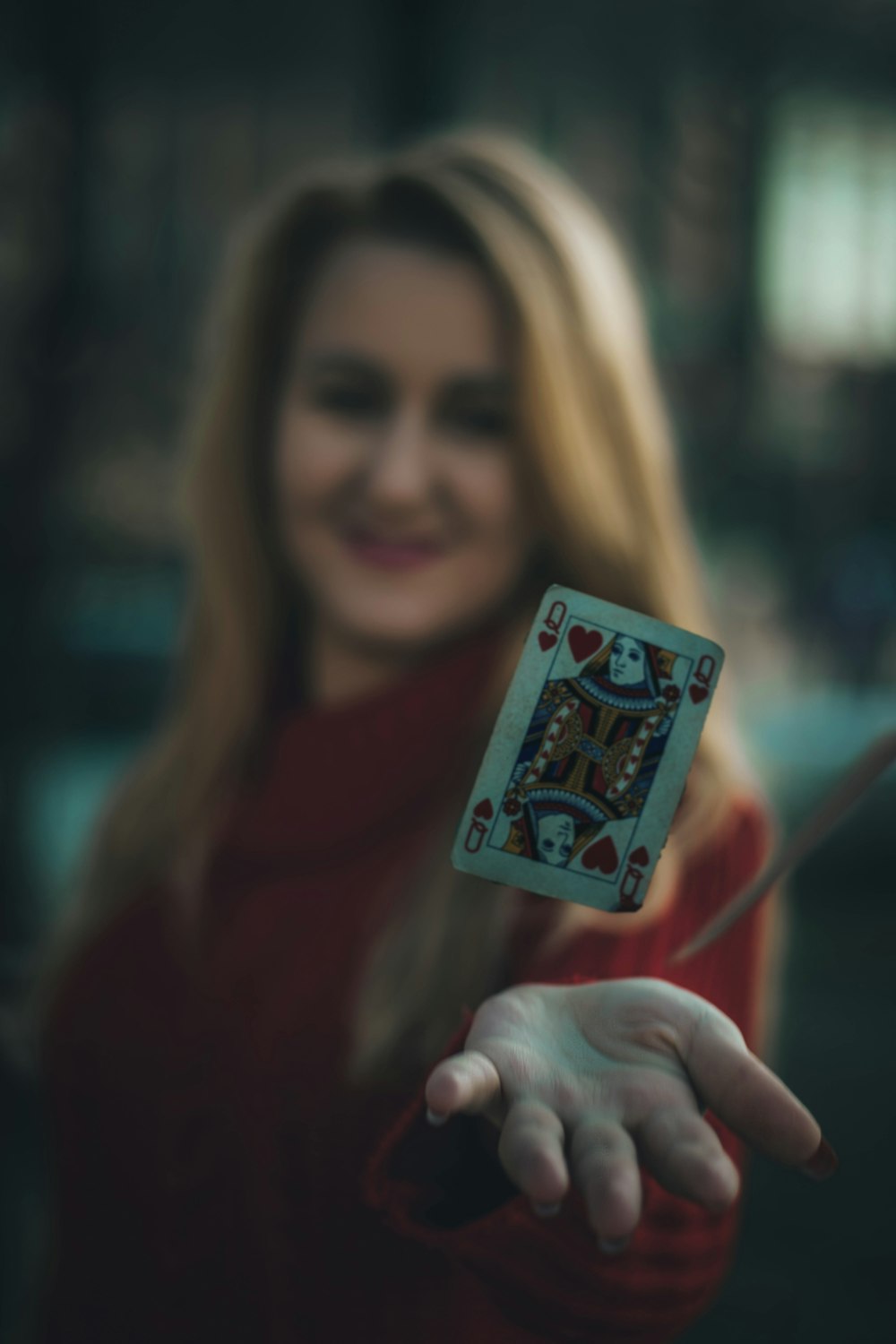 time lapse photo of queen of hearts playing card near woman's palm