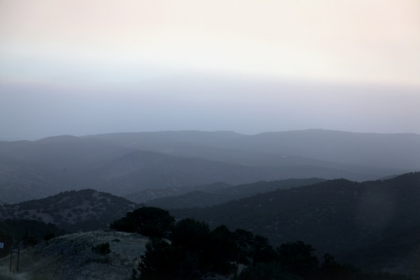 A minimalist landscape with gentle morning mist over rolling hills