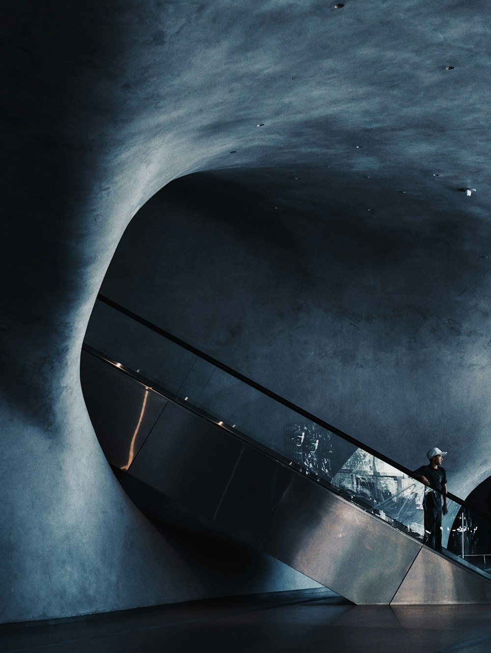 Mann steht auf Rolltreppe