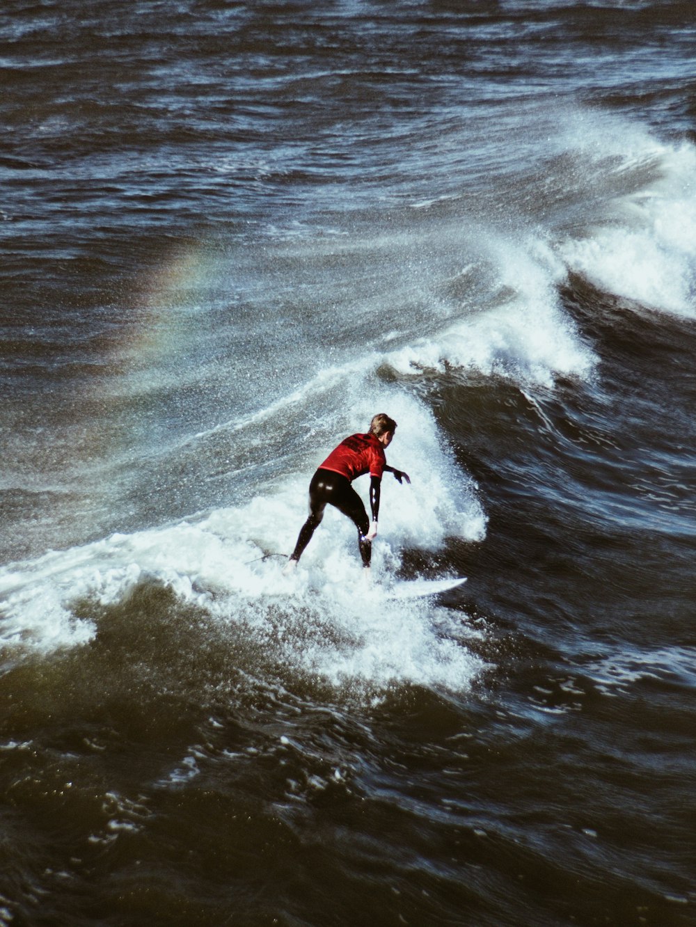 homem montando prancha de surf nas ondas do mar