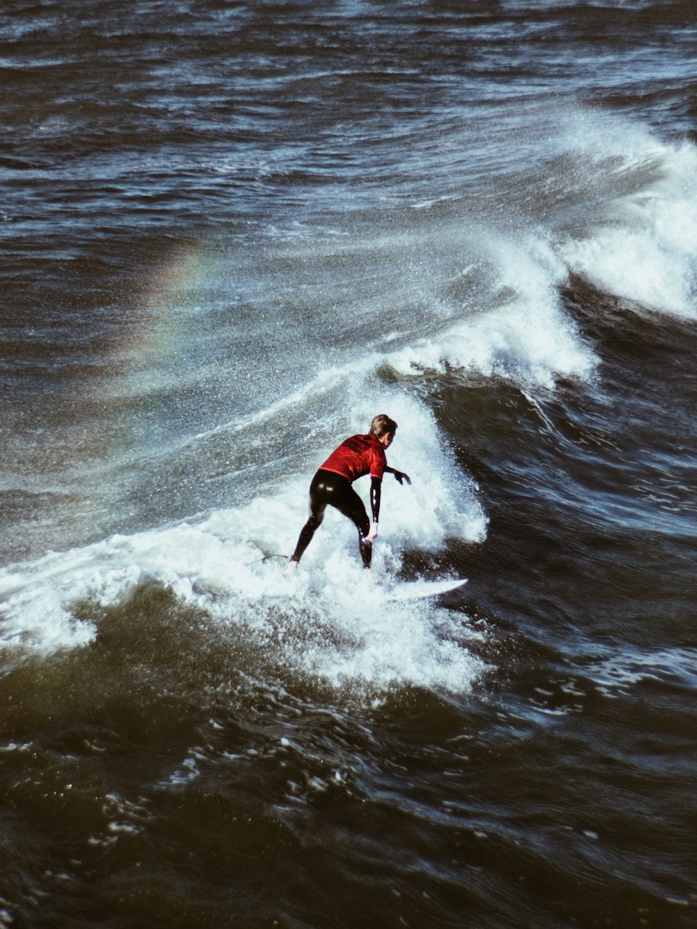 hombre montando tabla de surf en las olas del mar