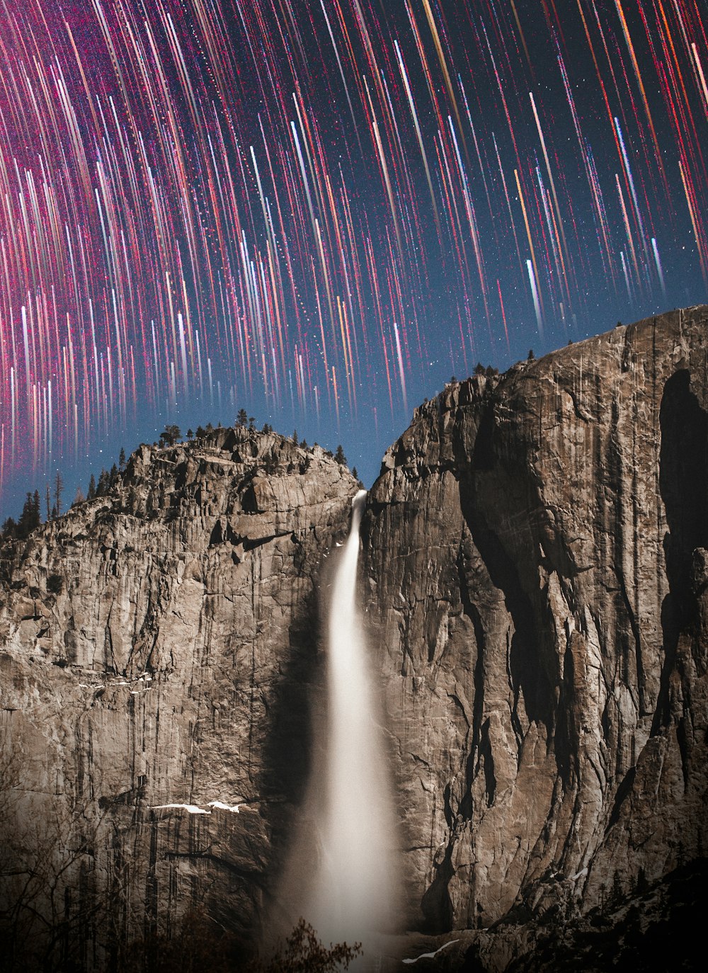 time lapse photography of stars and waterfalls