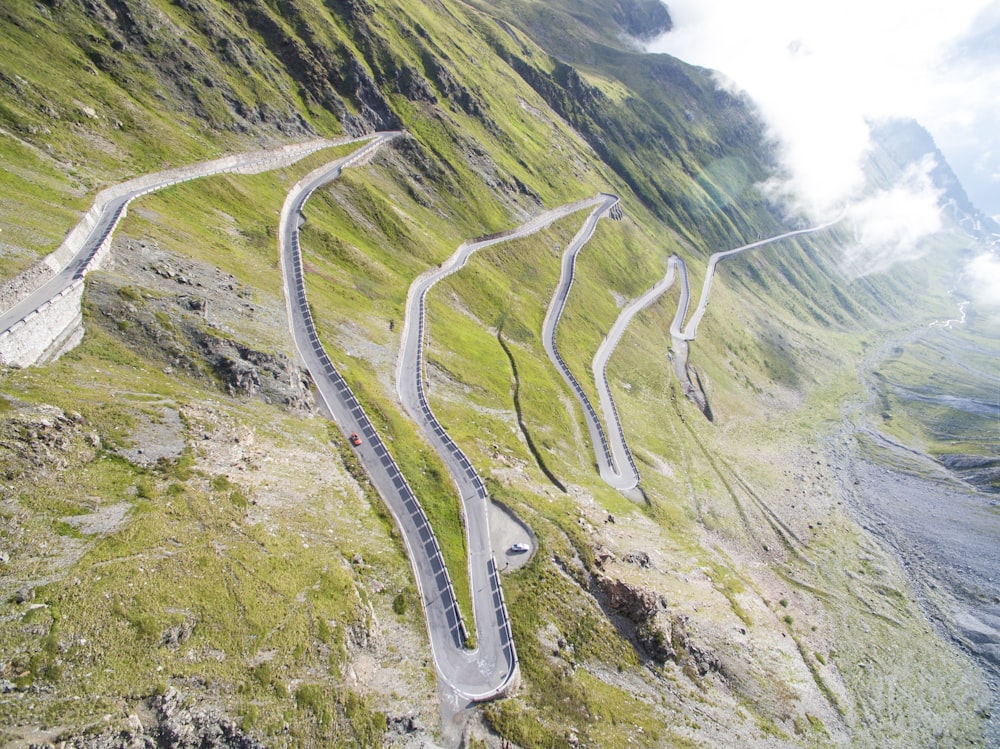 aerial view of concrete road between green grass fields