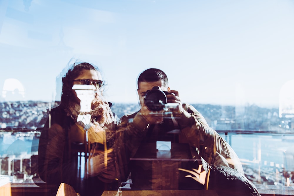 a man and a woman taking a picture with a camera