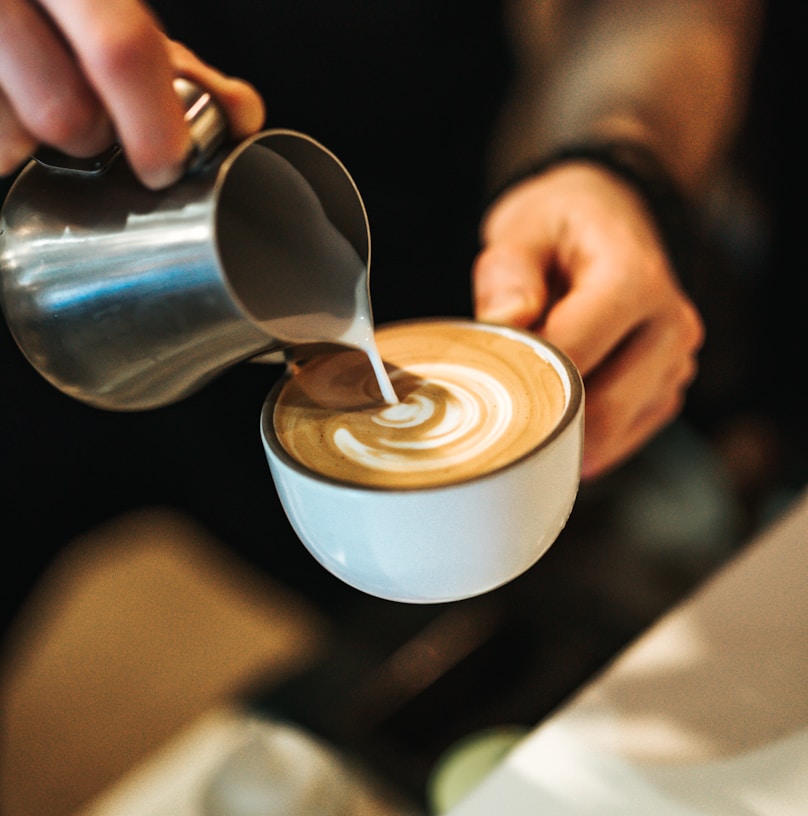 person preparing latte with art