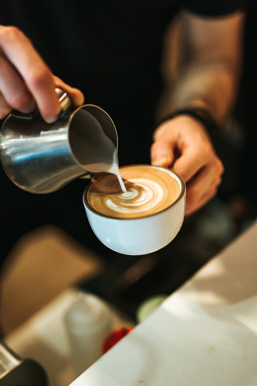 person preparing latte with art