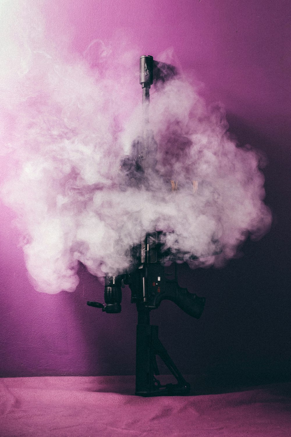 black assault rifle surrounded by smokes