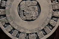 Mayan calendar stone showing intricate glyphs and celestial cycles.