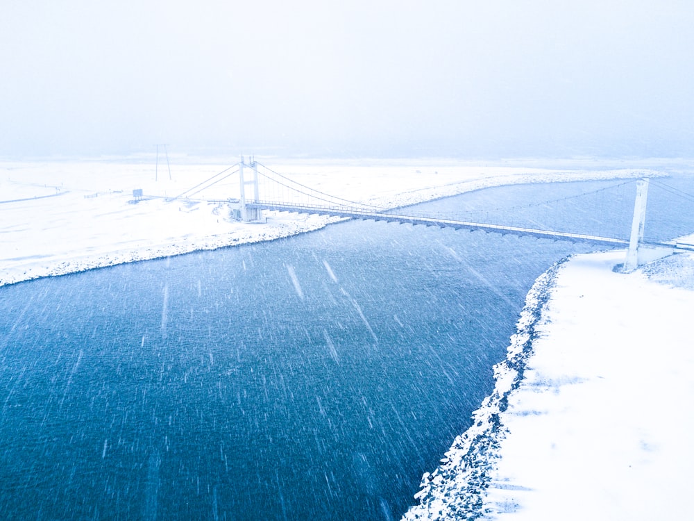 aerial view of bridge coat snow over body of water