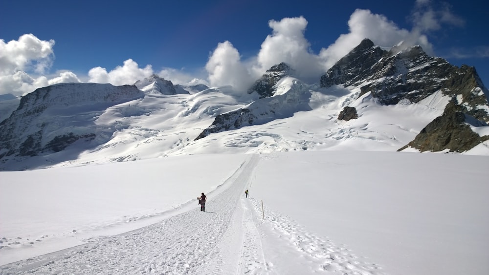 man walking through snowy mountain