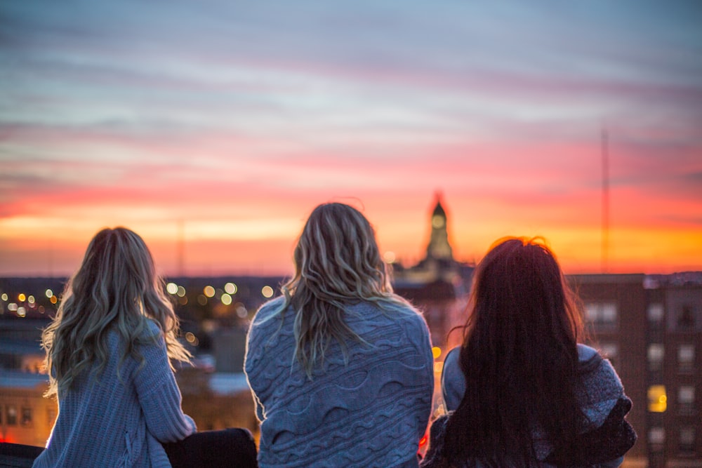 Foto de tres mujeres mirando hacia atrás mirando al horizonte