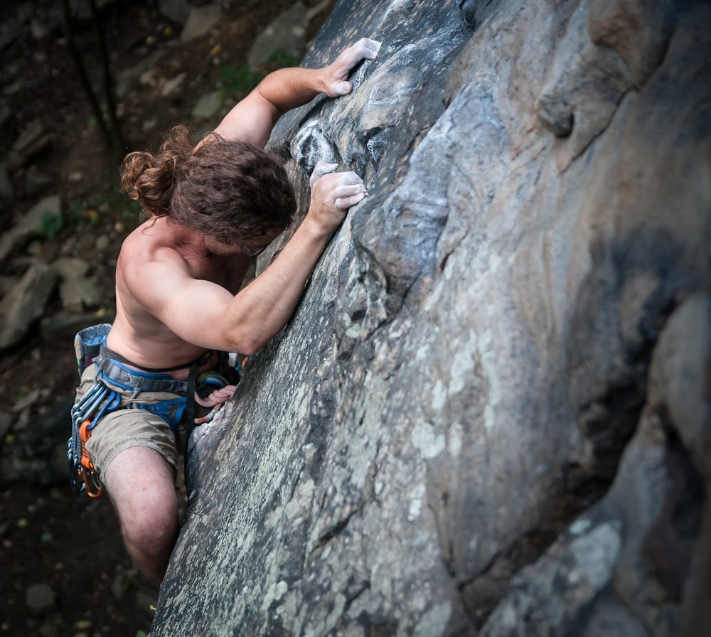 Un homme grimpant sur le flanc d’une montagne