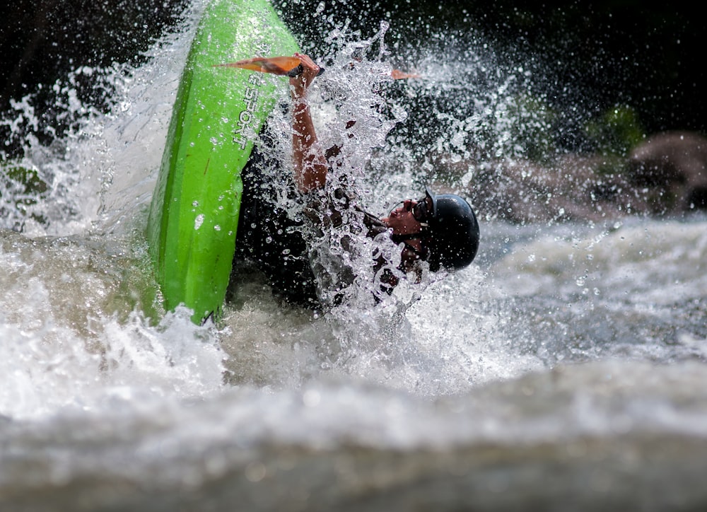 tilt-shift photography of man riding boat