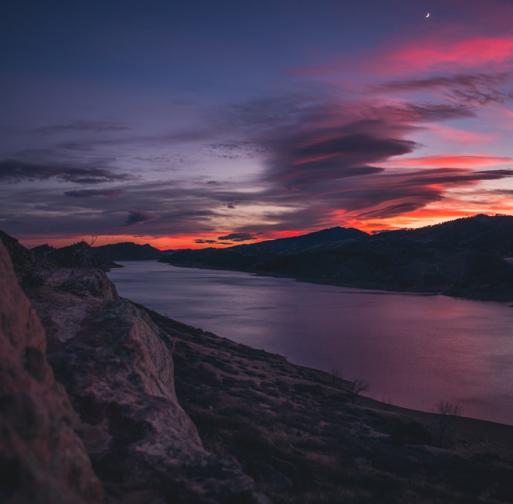 landscape photography of body of water near mountains