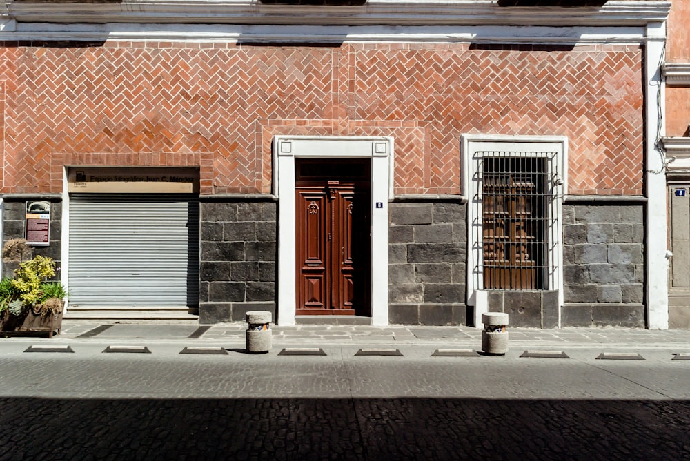 photo of closed brown wooden door beside roller shutter