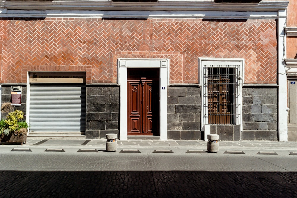 foto da porta de madeira marrom fechada ao lado da persiana