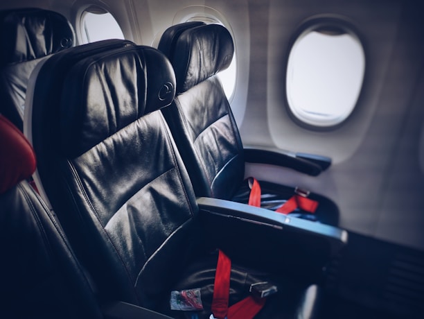 An elegant leather seat inside a private jet cabin bathed in soft natural light.