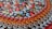 An assortment of colorful bottle caps neatly arranged in rows, showcasing various beverage brands. The caps include vibrant colors and recognizable logos from popular drinks like Coca-Cola, Fanta, Amstel, Fix, and Heineken.