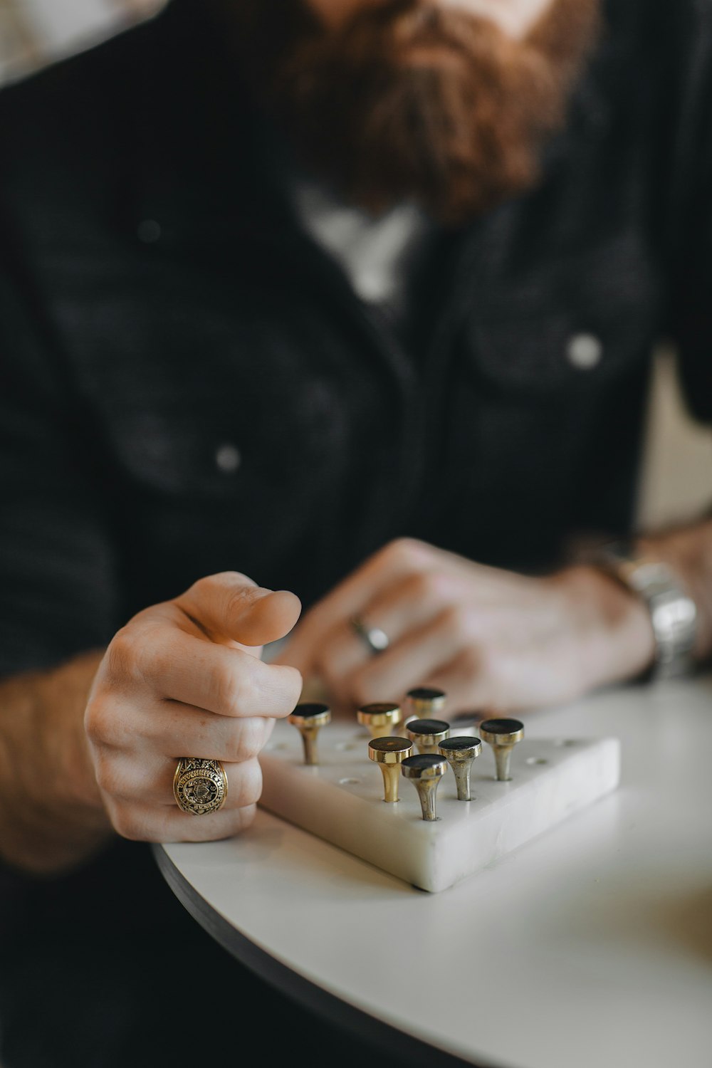 man looking on gold-colored taper gauge on desk