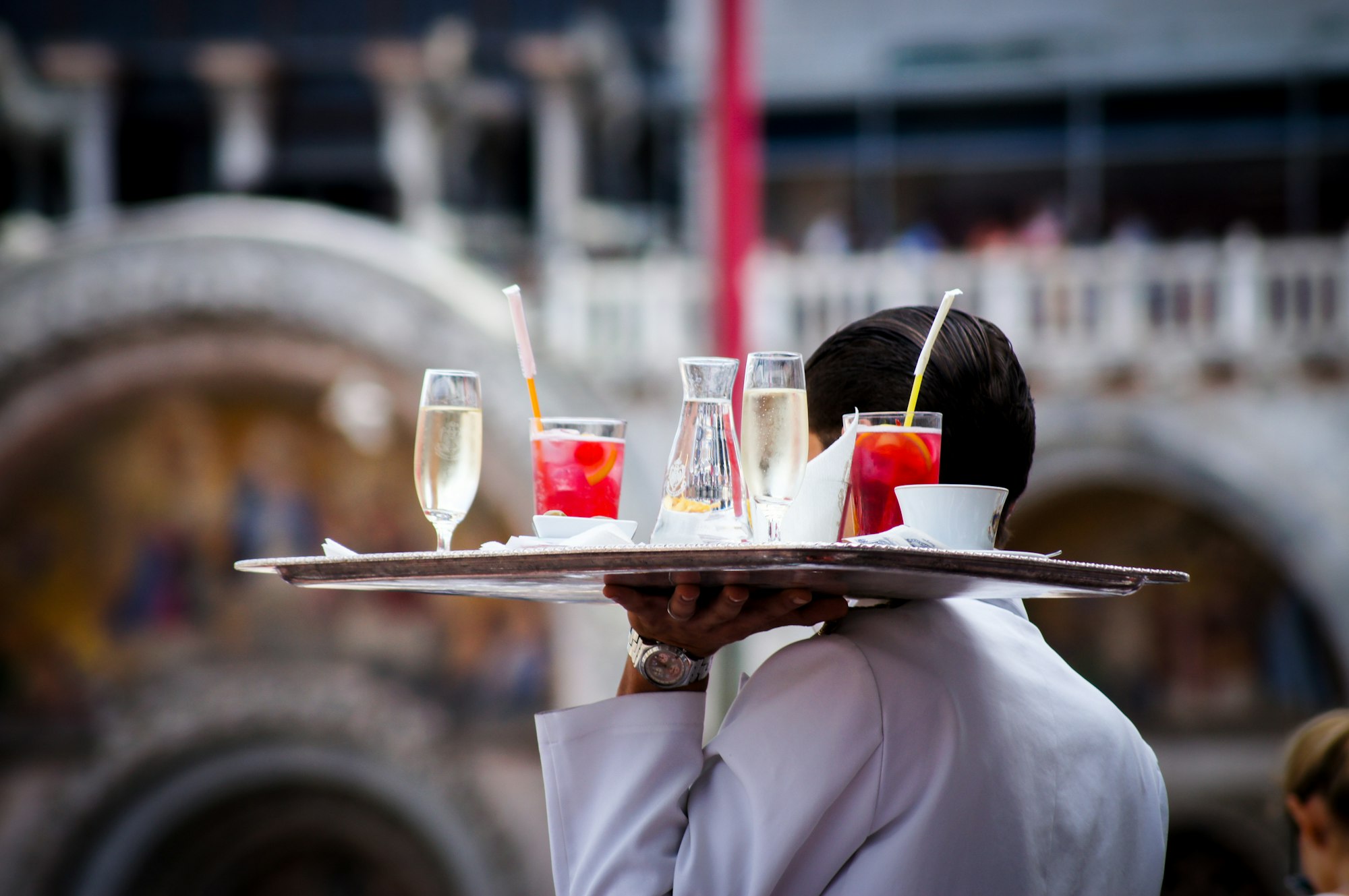 Waiter in a bar restaurant serving drinks and mocktails for patrons.