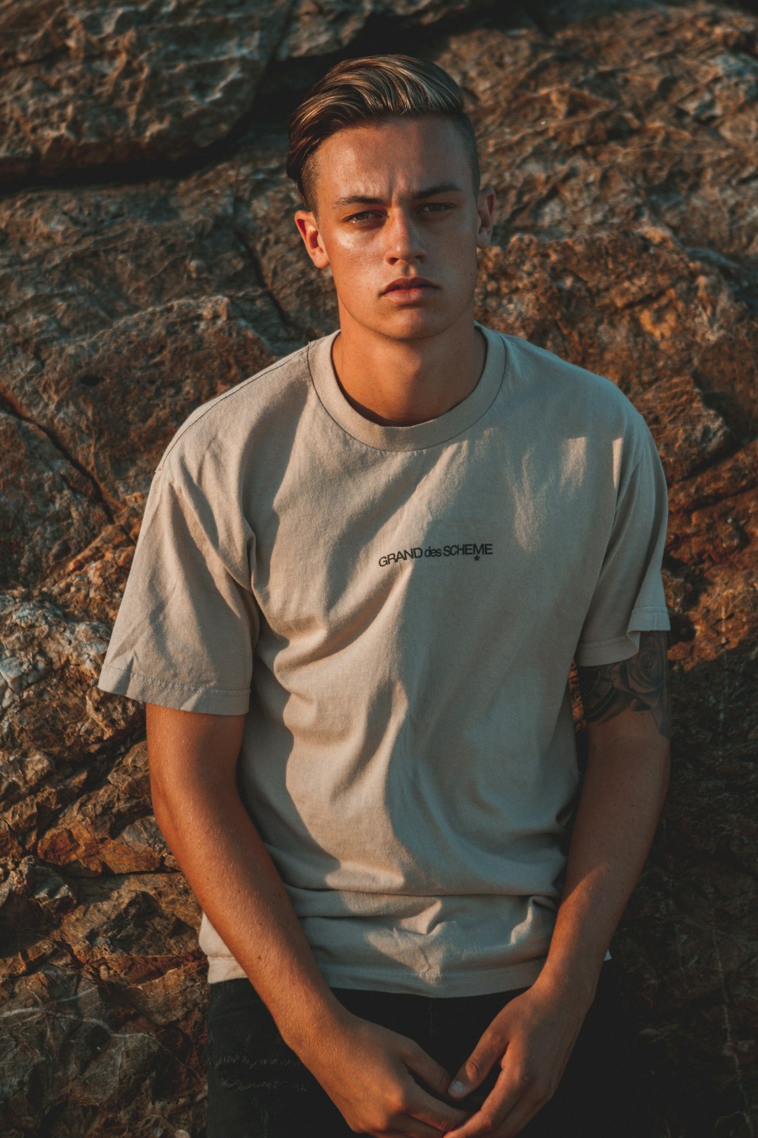 man leaning on rock while posing