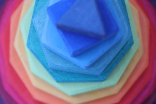 A colorful stack of building blocks forming a friendly handshake shape.