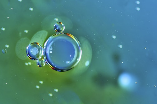 Close-up of soap bubbles shimmering in the light above a washing machine drum.