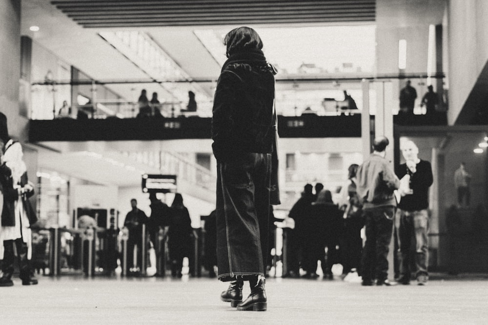 Foto en escala de grises de personas caminando dentro del edificio