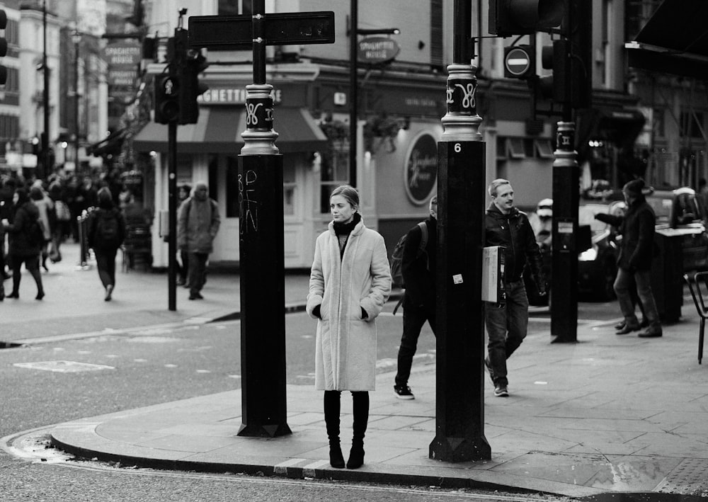 fotografia in scala di grigi di persone che camminano per strada durante il giorno