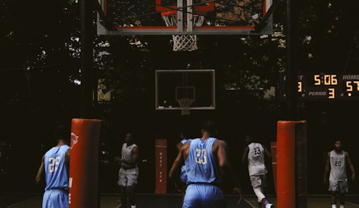 Children playing basketball passionately on an outdoor court during a school tournament.