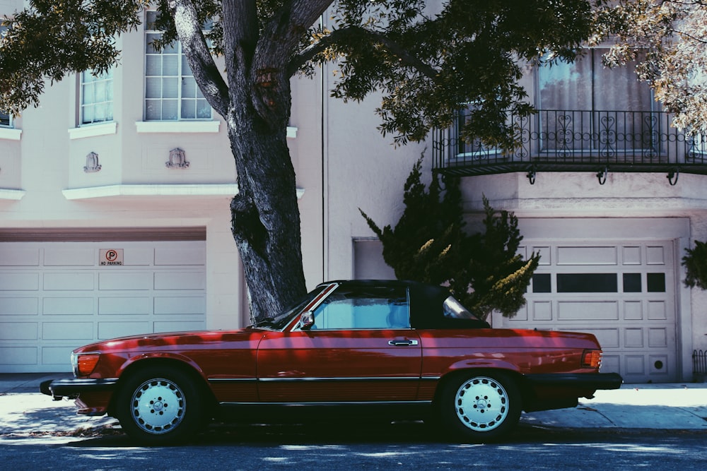 red Mercedes-Benz SLC 45 parked beside tree