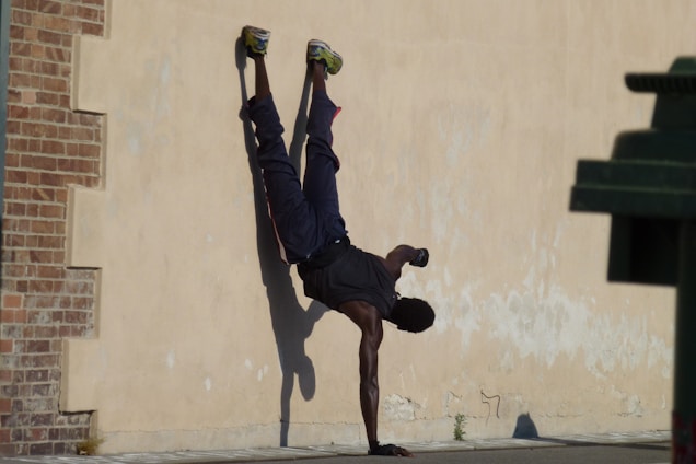 A person practicing a handstand outdoors, showcasing strength and balance.