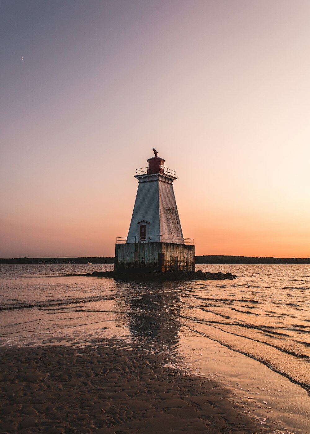 white lighthouse surrounded by body of water