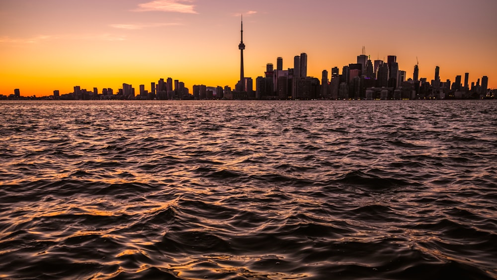 Edifici vicino allo specchio d'acqua sotto il tramonto arancione