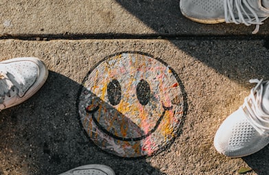 smiley paint on gray ground in front of people